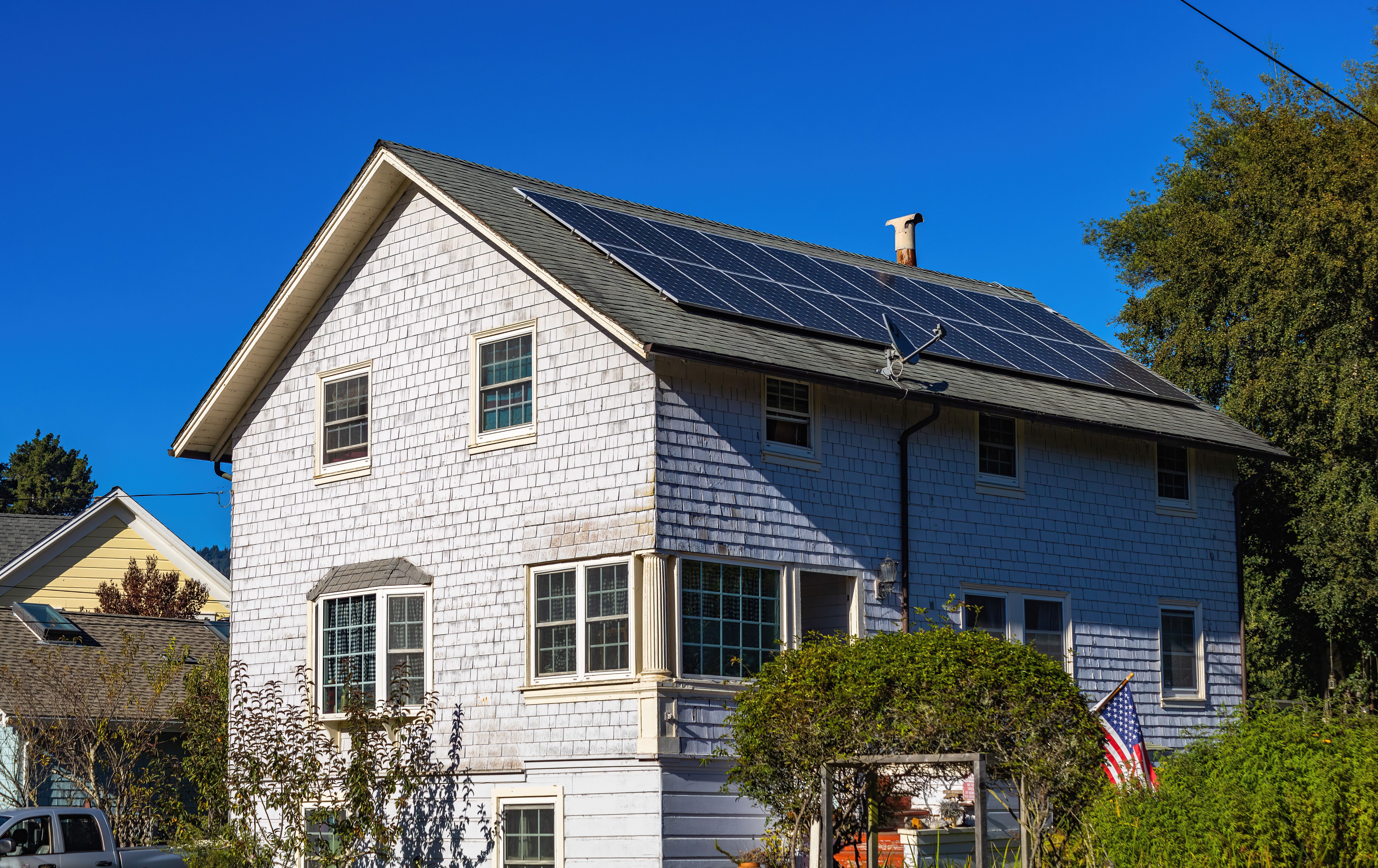 Modern home with rooftop solar panels under a clear blue sky, representing the completed customer journey.
