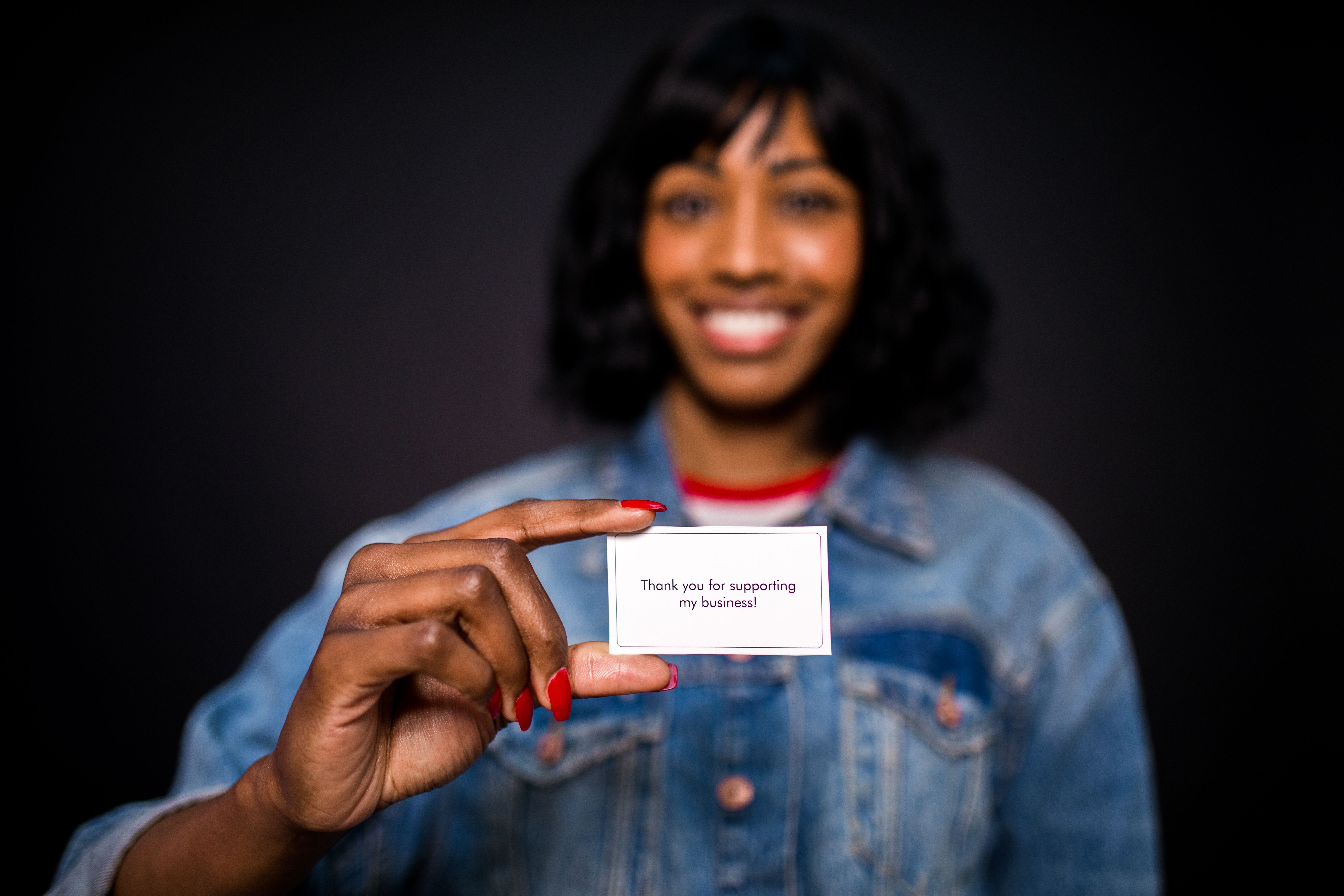 Smiling woman holding a thank-you card, representing appreciation throughout the customer relationship.